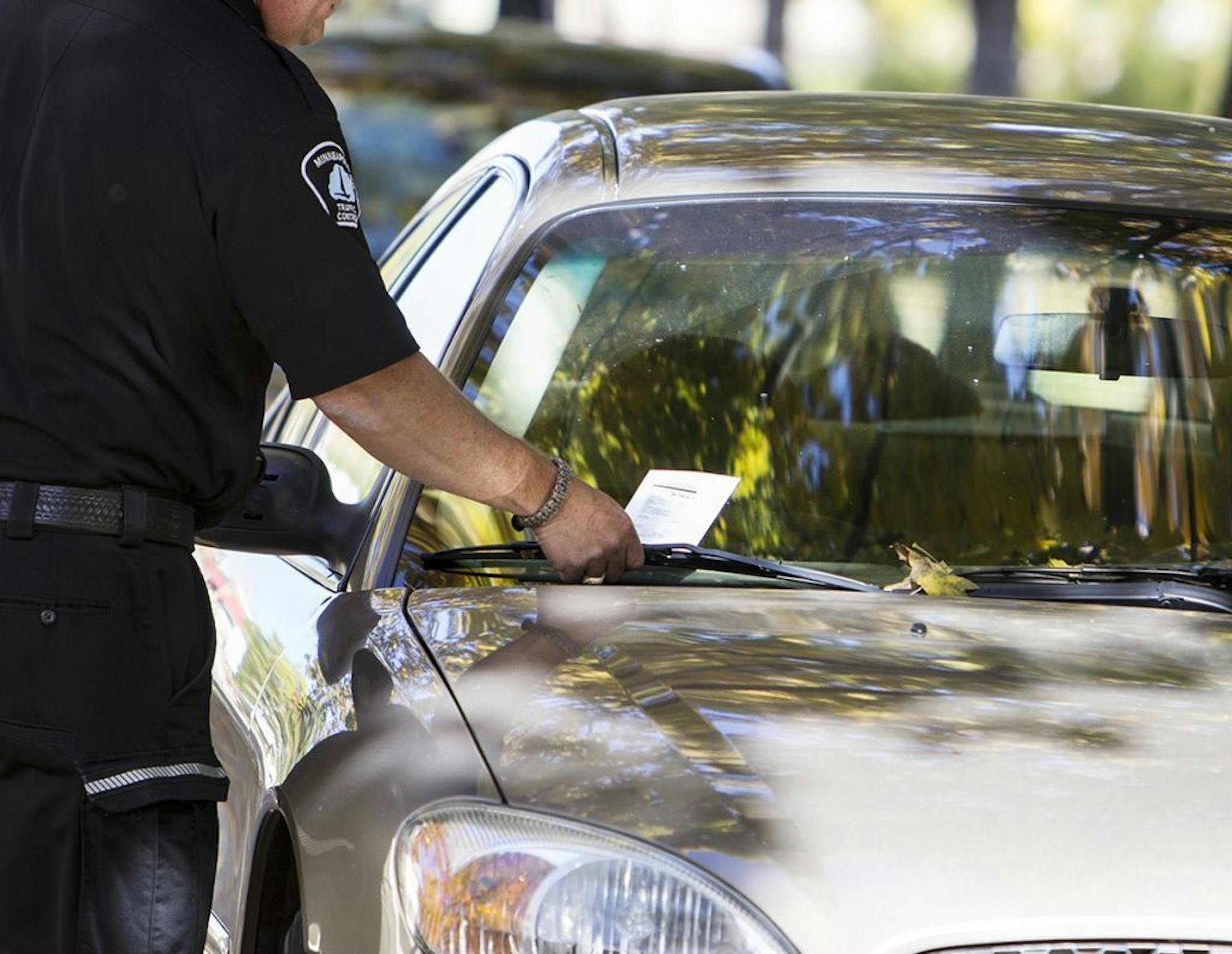 A Minneapolis Traffic Control officer who did not want to be named issued parking tickets during lunch hour on the 3100 block of Girard Avenue South in Minneapolis October 16, 2014. Multiple signs state that only cars with resident permits can park there, but the most ticketed location in the city is 3105 Girard Avenue South. (Courtney Perry/Special to the Star Tribune) ORG XMIT: MIN1410161415018057