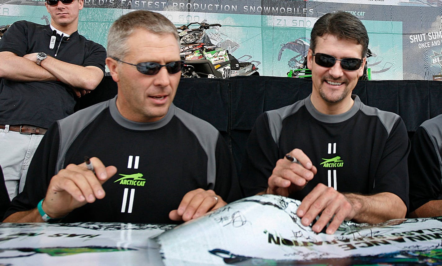 Todd Palin, right, husband of Republican vice presidential candidate, Alaska Gov. Sarah Palin, signs autographs with professional snowmobile partner Scott Davis at a group autograph event at the Hays Days Grass Drags snowmobile event in Forest Lake, Minn. Saturday Sept. 6, 2008. Palin, a professional racer, is the defending, with Davis, and four-time champion of the 1,971 mile Iron Dog snowmobile race while Davis is a seven-time champion in his home state of Alaska.