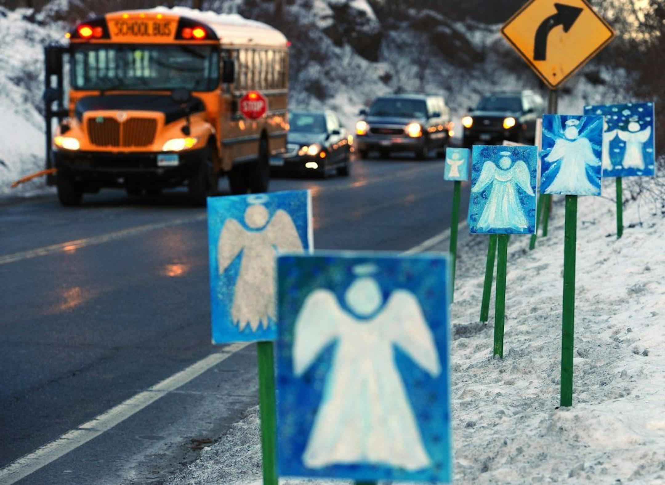 A bus traveling from Newtown, Conn., to Monroe stops in front of 26 angels along the roadside on the first day of classes for Sandy Hook Elementary School students since the Dec. 14 shooting, in Monroe, Conn., Thursday, Jan. 3, 2013. Chalk Hill School in Monroe was overhauled especially for the students from the Sandy Hook School shooting.