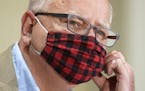 Minnesota Gov. Tim Walz wore his buffalo plaid cloth mask during a news conference Wednesday to announce statewide mask mandate, starting Saturday.
