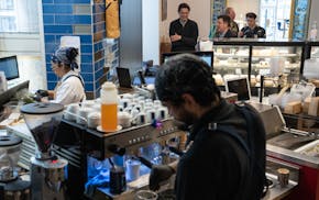 Neyda Villanueva, left, a kitchen manager, prepares sandwiches while David Garcia, a barista, fulfills drink orders, at Mother Dough in the Capella To