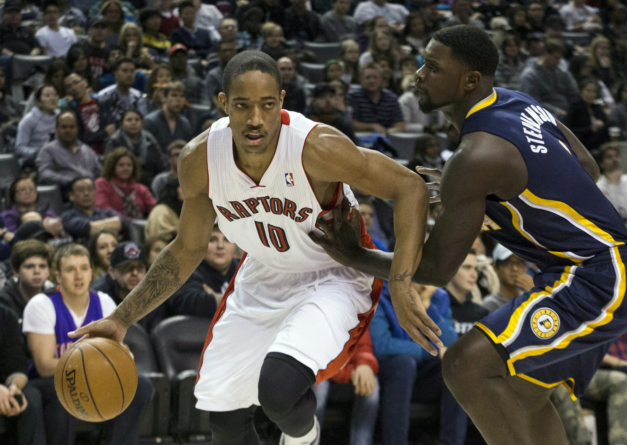 Toronto Raptors' DeMar DeRozan, left, drives at Indiana Pacers' Lance Stephenson during the first half of an NBA basketball game in Toronto on Wednesday, Jan. 1, 2014. (AP Photo/The Canadian Press, Chris Young)