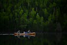 Tony Jones, his dog Crosby, and Bob Timmons paddled from Mountain Lake toward their portages to Moose Lake Friday. 
]   Aaron Lavinsky ¥ aaron.lavins