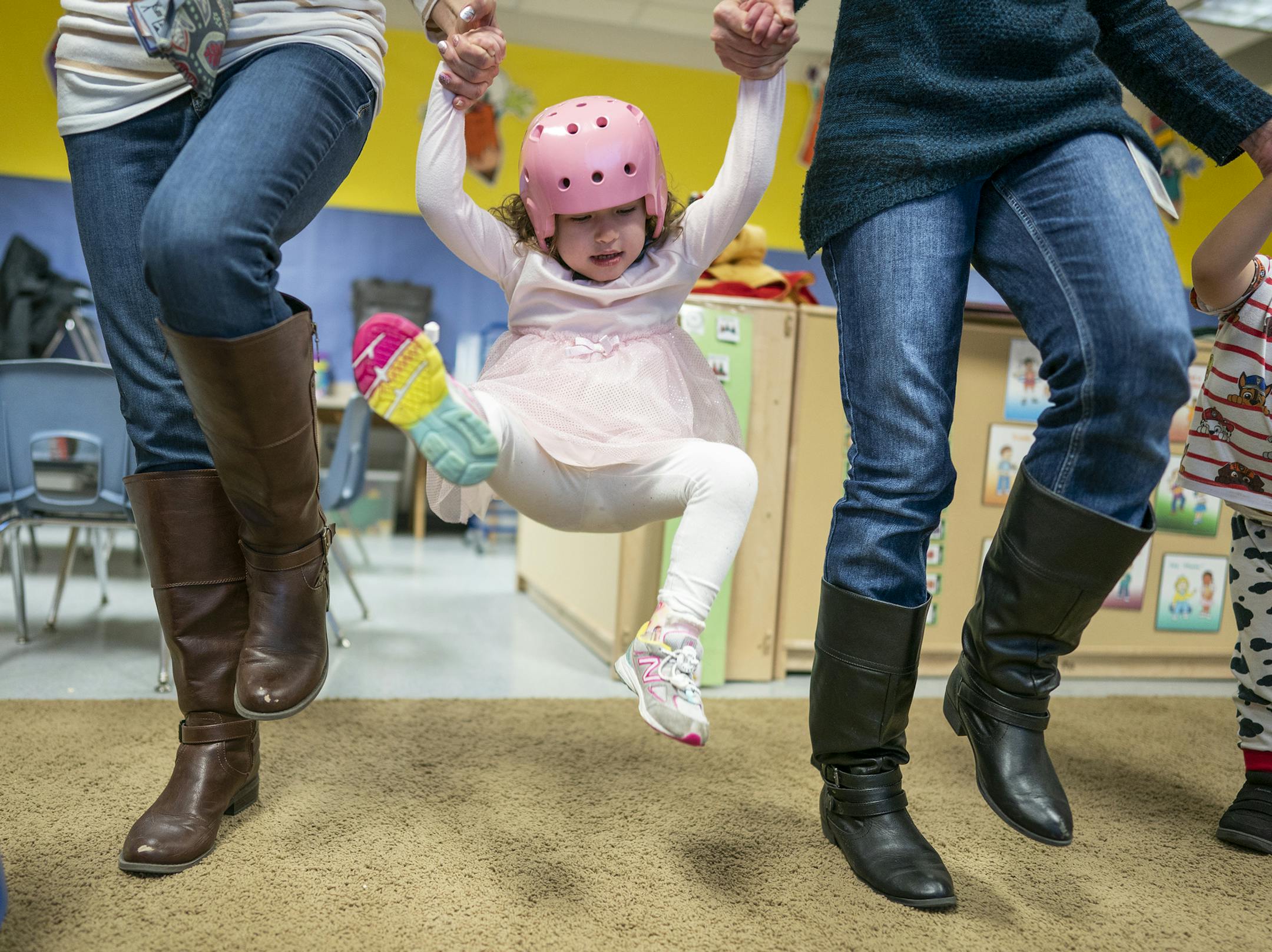 Hazel Norris dances and jumps with the help of teacher Kristin Rutz, left, and assistant Connie Kain. ] LEILA NAVIDI ¥ leila.navidi@startribune.com BACKGROUND INFORMATION: Hazel Norris, 3, goes to Early Childhood Special Education preschool at Otsego Elementary School with her at home nurse Rachael Hatcher in Otsego on Thursday, May 9, 2019. Three-year-old Hazel Norris has intractable epilepsy. She needs around-the-clock monitoring to care for her frequent seizures, a level of medical care