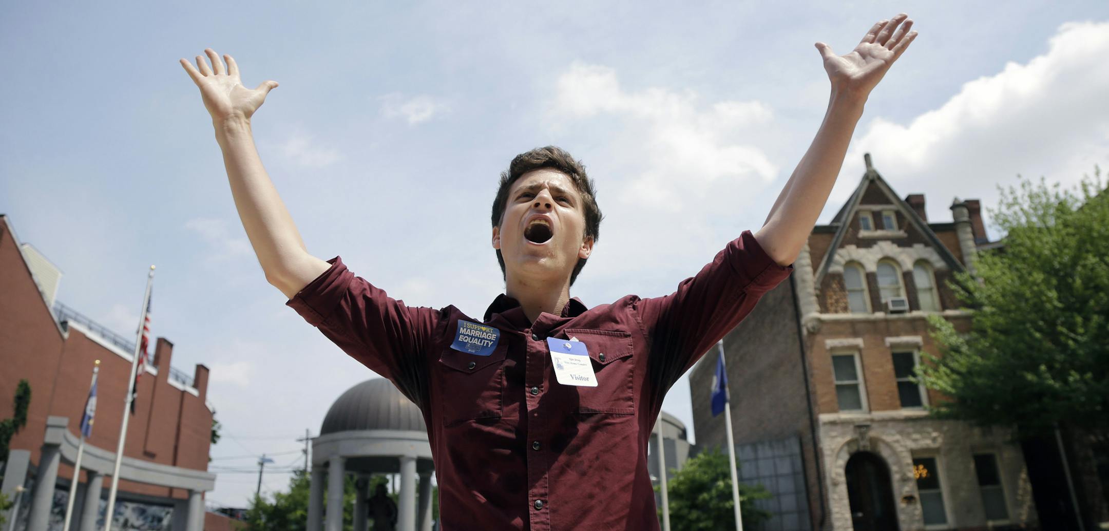 Christian Olivera, of Newark, N.J., shouts toward the Statehouse Thursday, June 27, 2013, in Trenton, N.J., as he and other advocates for gay marriage in New Jersey gather, saying they'll press their case in the Legislature and the courts after the U.S. Supreme Court ruling that invalidates parts of the federal Defense of Marriage Act. Gov. Chris Christie said he would again veto a same-sex marriage bill if it reaches his desk, and that Wednesday's U.S. Supreme Court ruling striking down a ban o