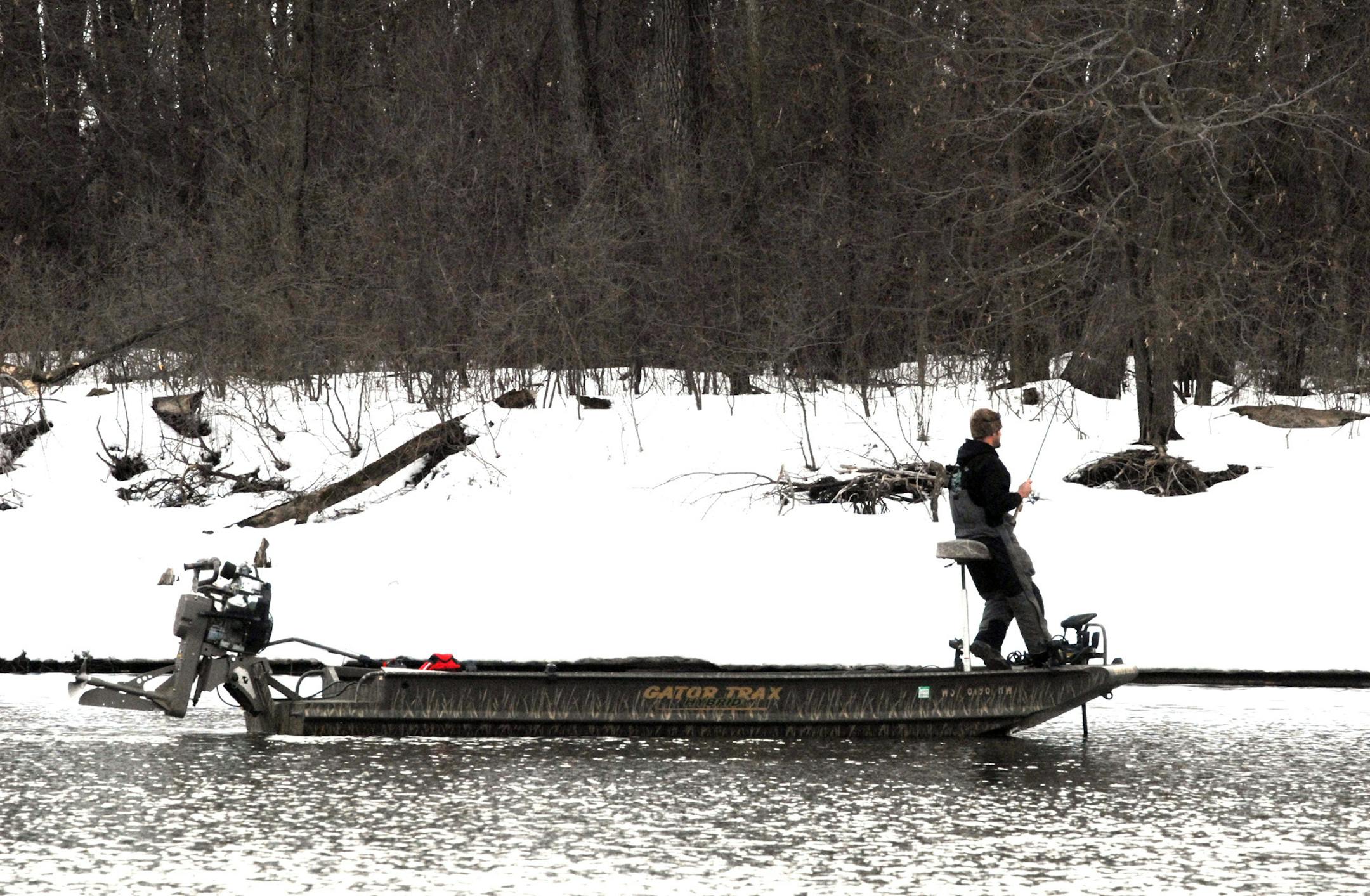 In a shallow-running boat rigged with a surface-drive outboard, an angler pitches his bait toward shore, looking for walleyes.