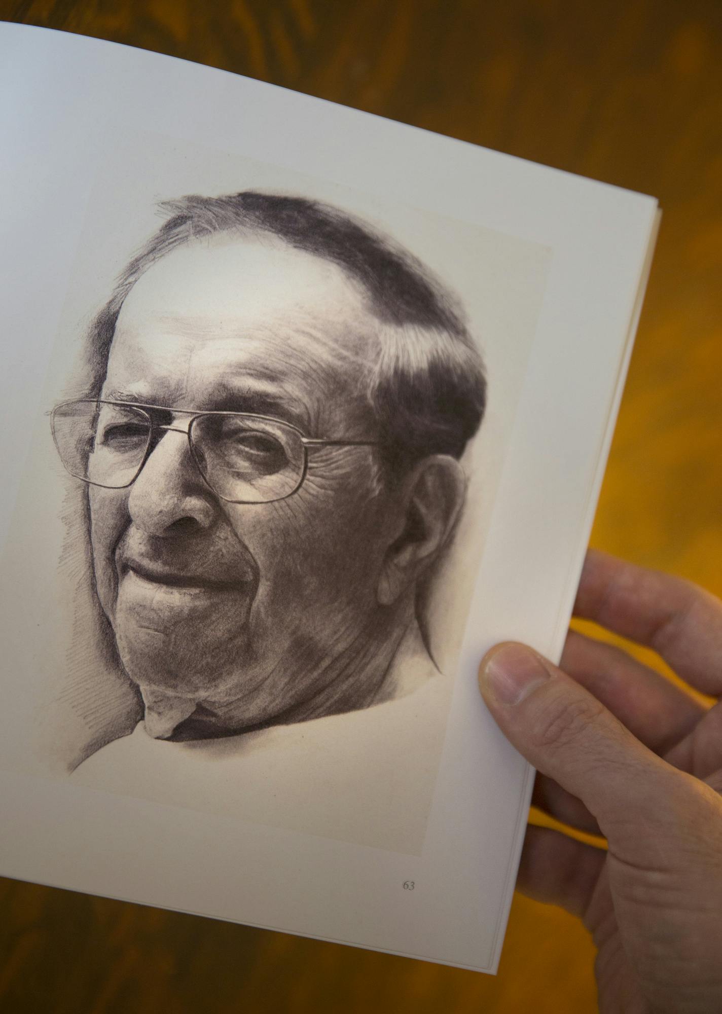 Local artist Rowan Pope holds a copy of the book "Six Chairs: A Holocaust Survivor's Story" with an illustration he made of Holocaust survivor Joe Grosnacht inside his home studio in St. Paul. ] LEILA NAVIDI leila.navidi@startribune.com / BACKGROUND INFORMATION: Friday, January 30, 2015. Rowan Pope, in collaboration with Breck Middle School, wrote the book "Six Chairs: A Holocaust Survivor's Story" which was illustrated by Breck Middle School students about local Holocaust survivor Joe Grosnacht