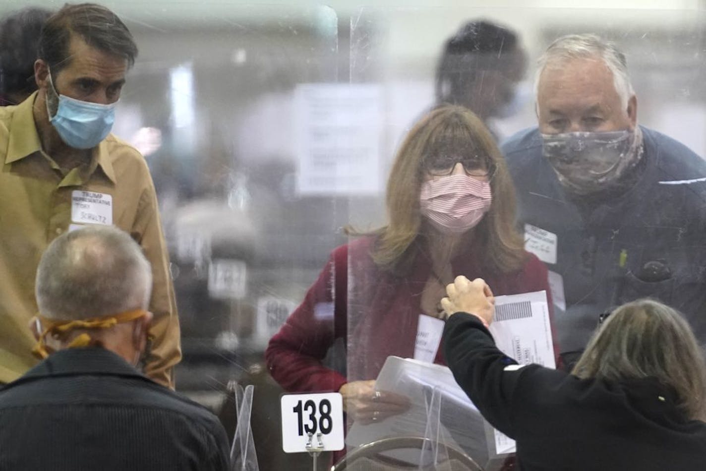 Recount observers check ballots during a hand recount of presidential votes at the Wisconsin Center, Friday, Nov. 20, 2012, in Milwaukee.