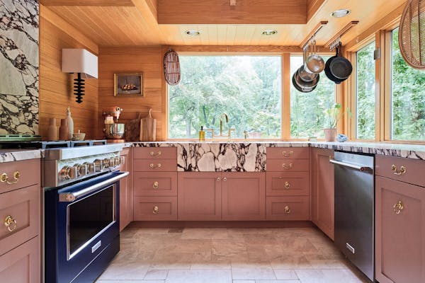 Wit and Delight blogger Kate Arends Peters updated her St. Paul kitchen with pink cabinetry, a blue range and Calacatta Viola marble countertops that 