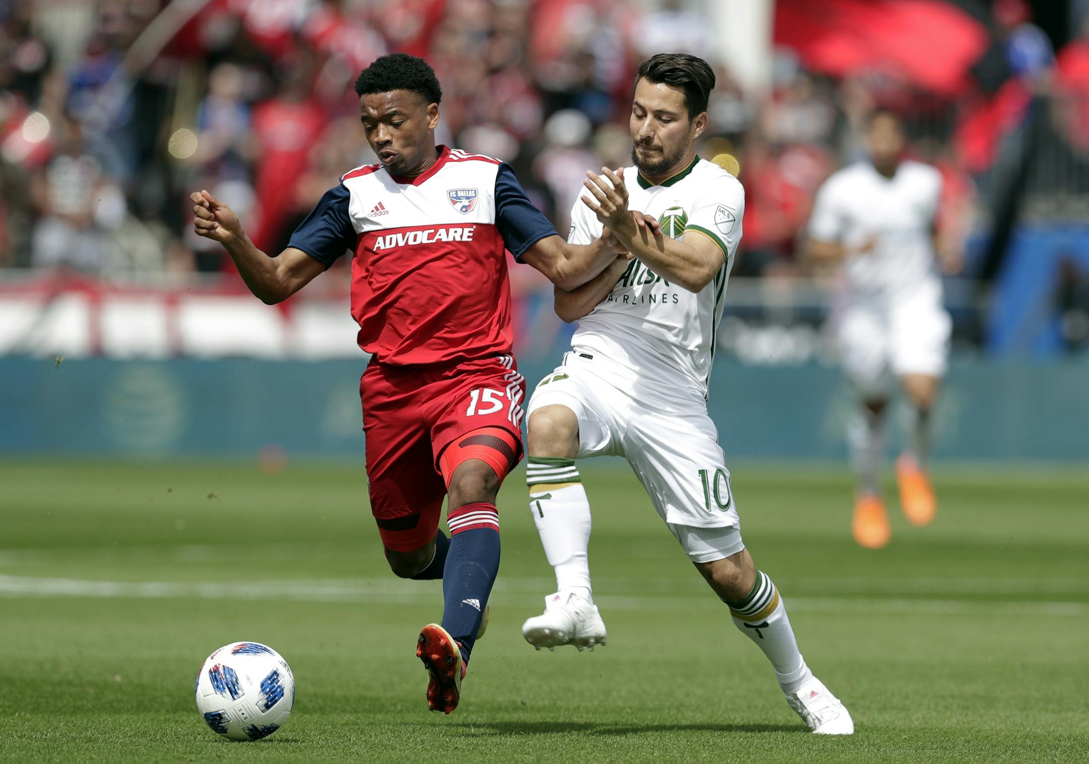 FC Dallas's Jacori Hayes (15) and Portland Timbers's Sebastian Blanco (10) compete for a loose ball during an MLS soccer match on March 24, 2018 in Frisco, Texas.