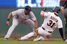 Tigers third baseman Jeimer Candelario, left, tags out Minnesota Twins' Tyler Austin in August