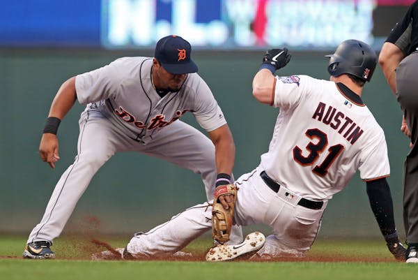Tigers third baseman Jeimer Candelario, left, tags out Minnesota Twins' Tyler Austin in August