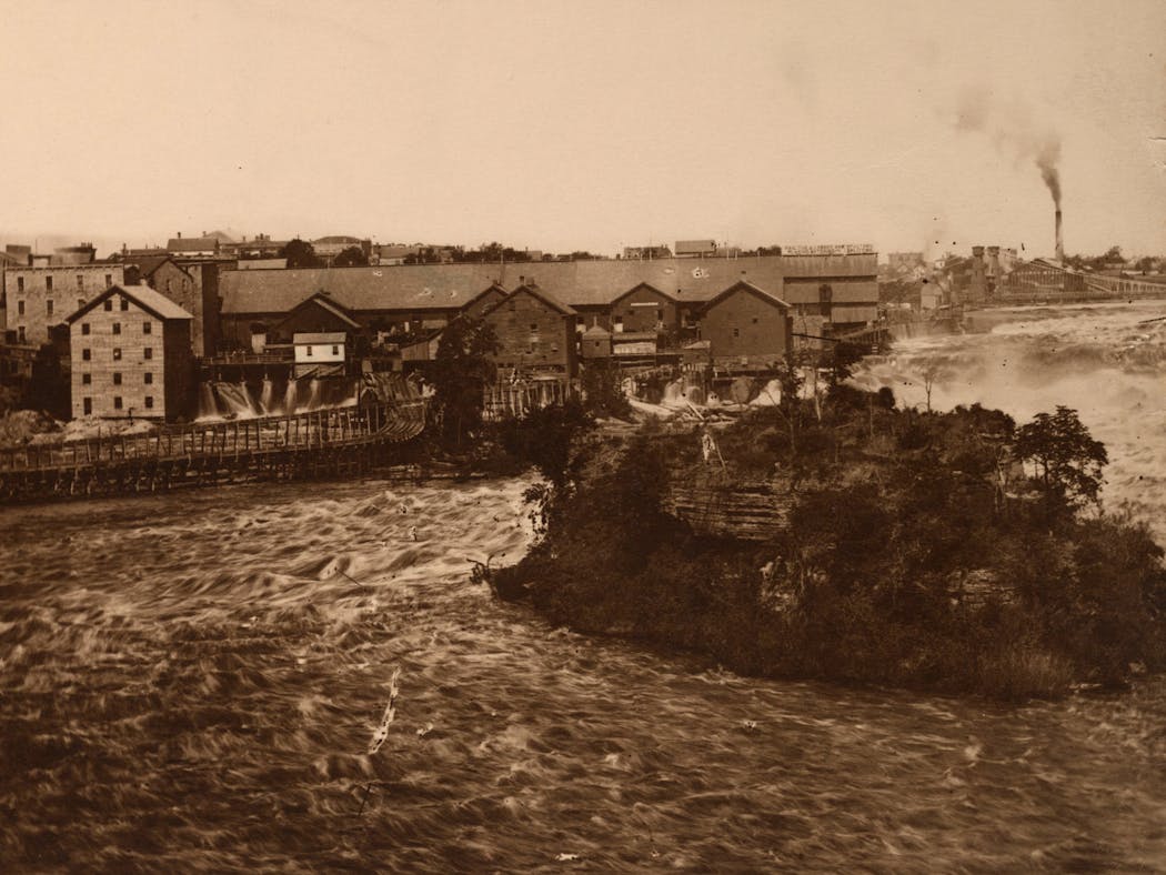 Spirit Island alongside lumber mills on the Minneapolis riverfront in approximately 1869.
