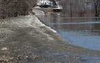 High water rushes over Highway 19 as melting snow along the Minnesota River is causing flooding and closing down three of four highways heading into t