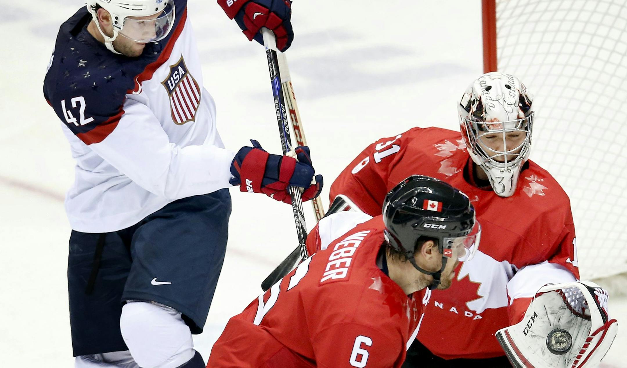 With pressure from USA's David Backes (42), Team Canada goalie Carey Price (31) made a save in the second period in the men's hockey semifinal at Bolshoy Ice Dome during the Winter Olympics in Sochi, Russia, Friday, Feb. 21, 2014. Canada beat USA 1-0. (Carlos Gonzalez/Minneapolis Star Tribune/MCT) ORG XMIT: 1149489 ORG XMIT: MIN1402211536564457