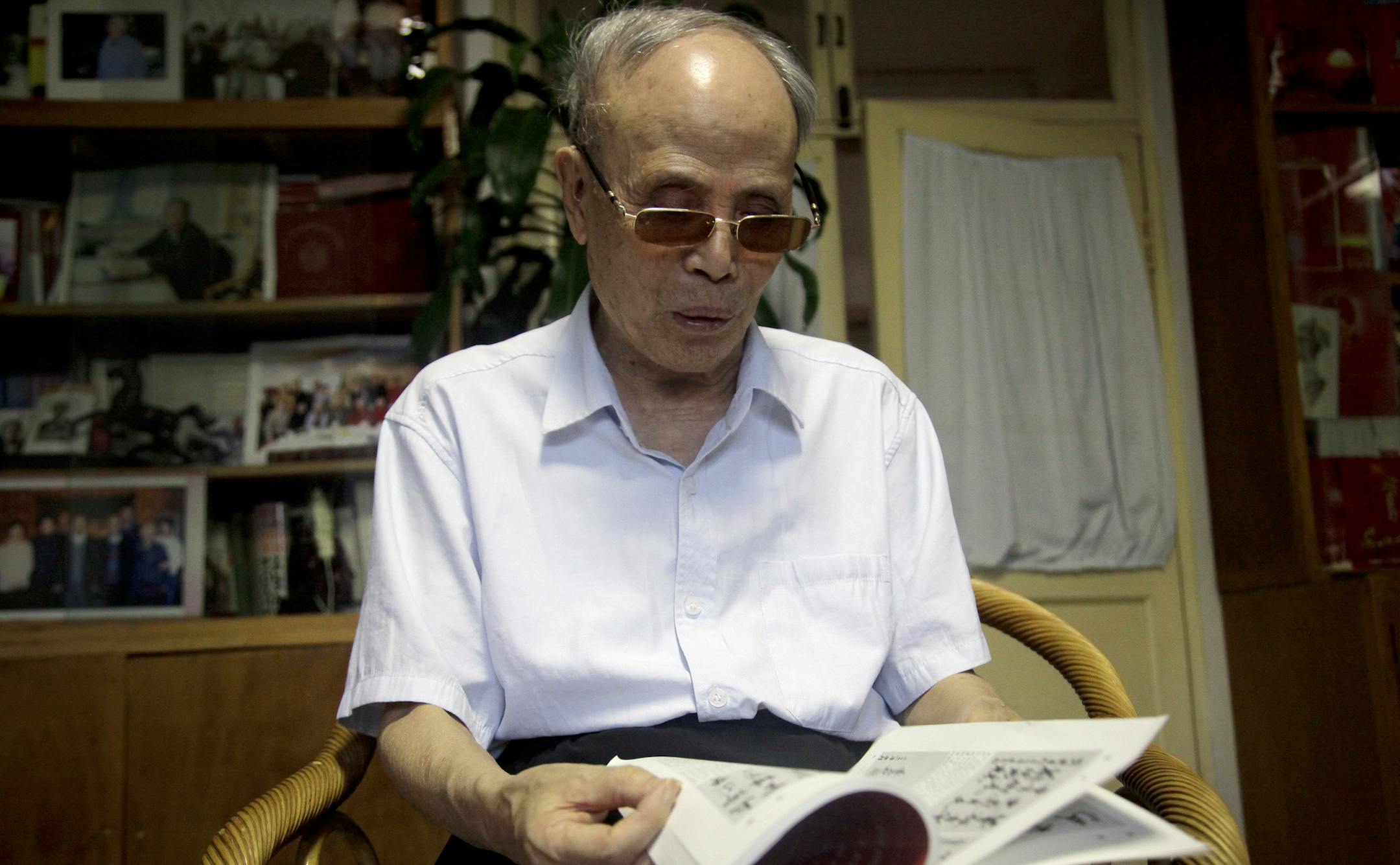 In this Tuesday, July 19, 2016 photo, Du Daozheng browses his Yanhuang Chunqiu magazine during an interview at his home in Beijing. Du, a 93-year old publisher, a former aide to the ousted Communist Party leader Zhao Ziyang and a stalwart of the party's liberal wing, announced this week the suspension of the magazine, Yanhuang Chunqiu, after government officials ordered a leadership reshuffle and seized its offices and servers. (AP Photo/Gerry Shih) ORG XMIT: XAW103