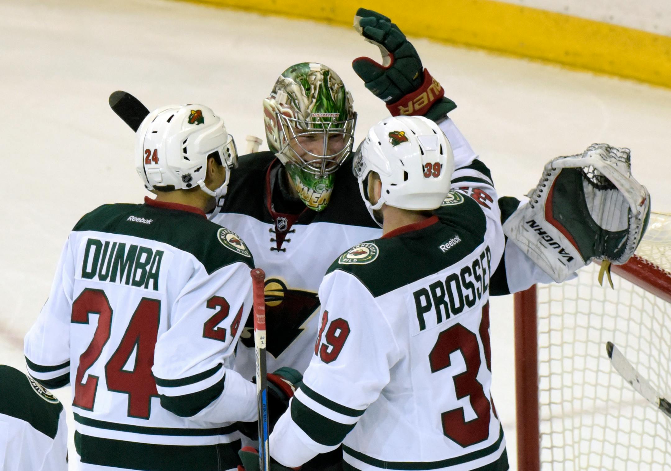 Minnesota Wild goaltender Darcy Kuemper celebrates with Matt Dumba (24) and Nate Prosser (39) after the Wild defeated the New York Rangers 7-4 in an NHL hockey game Friday, Dec. 23, 2016, at Madison Square Garden in New York. (AP Photo/Bill Kostroun)