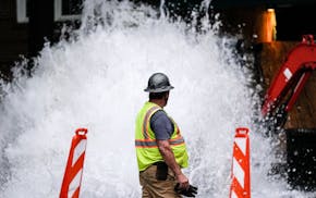 A crew member walks near a broken water transmission line, Saturday, June 1, 2024, in Atlanta.