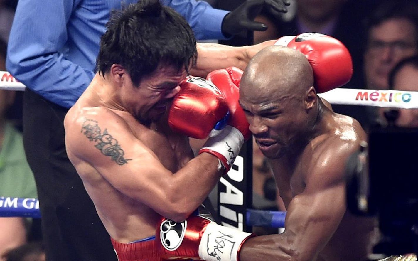 FLoyd Mayweather Jr., right, lands a punch to Manny Pacquaio in the fourth round of the WBC Welterweight Championship at the MGM Grand Garden Arena in Las Vegas on Saturday, May 2, 2015. Mayweather won in a unaniomous decision.