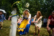 Sisters Natalie Redinger, center, and Heather Dewitt, center right, dance around a maypole at the American Swedish Institute in 2021.