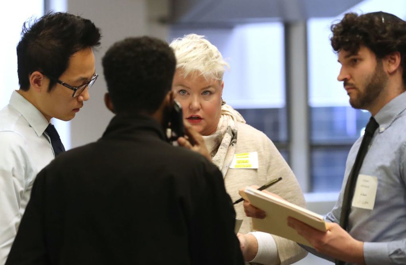 From left, David Moon Tara Murphy and Kyle Luebke, volunteer attorneys for the University of Minnesota Law School's Center for New Americans, talked to the relative of a traveler at the airport.