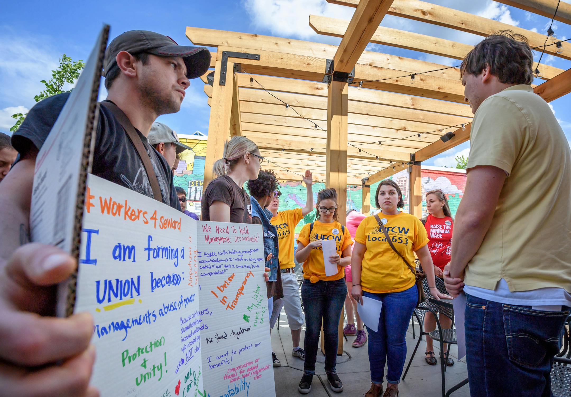 A group of Seward Co-op workers and a allied organizations walked past the Co-op Creamery to Seward Co-op offices and presented their issues to Operations Manager Nick Seeberger, right. ] GLEN STUBBE � glen.stubbe@startribune.com Thursday June 8, 2017 In the largest union effort to organize food coops in Twin Cities history, more than three fourths of about 290 workers employed by a Minneapolis food coop and its three facilities have signed cards asking to be recognized as a union. They held a m