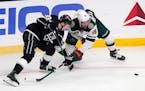 Los Angeles Kings defenseman Tobias Bjornfot, left, and Minnesota Wild left wing Jordan Greenway vie for the puck during the first period