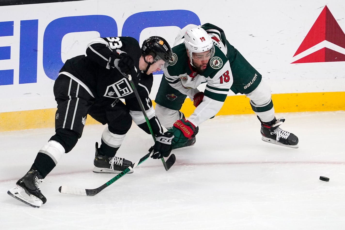 Los Angeles Kings defenseman Tobias Bjornfot, left, and Minnesota Wild left wing Jordan Greenway vie for the puck during the first period