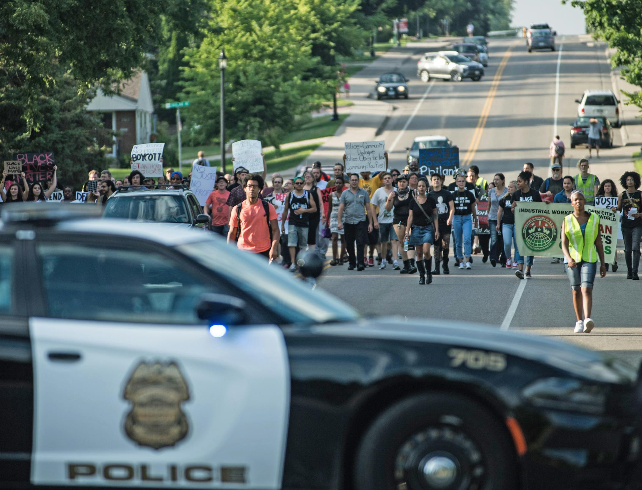 Demonstrators marched down Silver Lake Road in St. Anthony Village on their way to protest outside of St. Anthony Village Wine and Spirits, a municipal liquor store that contributes to the city's police budget. ] Aaron Lavinsky, St. Anthony Village, MN 7/30/2016
