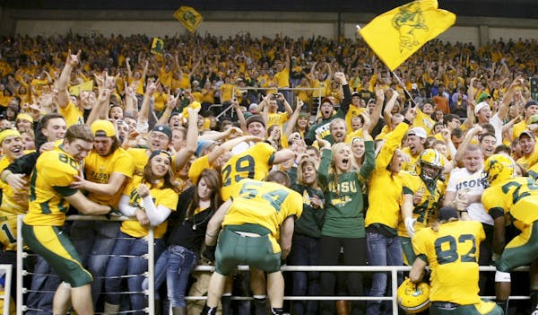 File - In this Dec. 14, 2012, file photo, North Dakota State players climb into the stands to celebrate with fans after defeating Georgia Southern in 