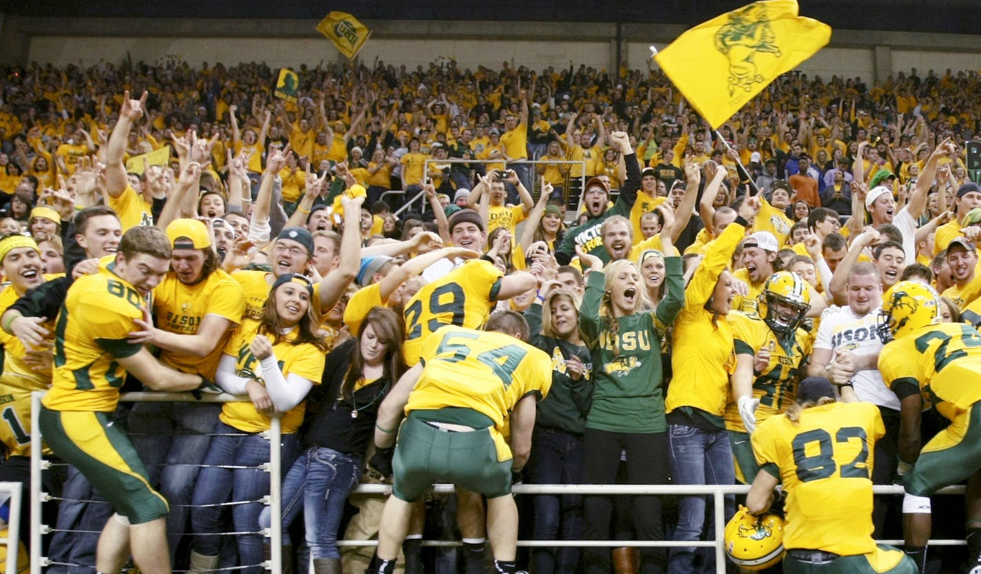 File - In this Dec. 14, 2012, file photo, North Dakota State players climb into the stands to celebrate with fans after defeating Georgia Southern in an FCS Championship semifinal college football game at the Fargodome in Fargo, N.D. ESPN is taking its College GameDay show to Fargo on Saturday, Sept. 21, 2013, for North Dakota State's NCAA college football game game against Delaware State. Some Bison fans are ecstatic while others are grumbling about ESPN setting up downtown near the Fargo Theat