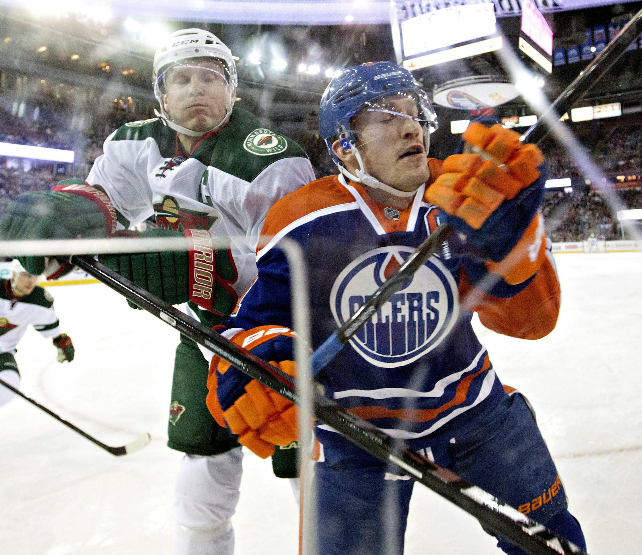 Minnesota Wild's Mikko Koivu (9) checks Edmonton Oilers' Andrew Ference during the first period of an NHL hockey game Friday, Feb. 20, 2015, in Edmonton, Alberta. (AP Photo/The Canadian Press, Jason Franson)