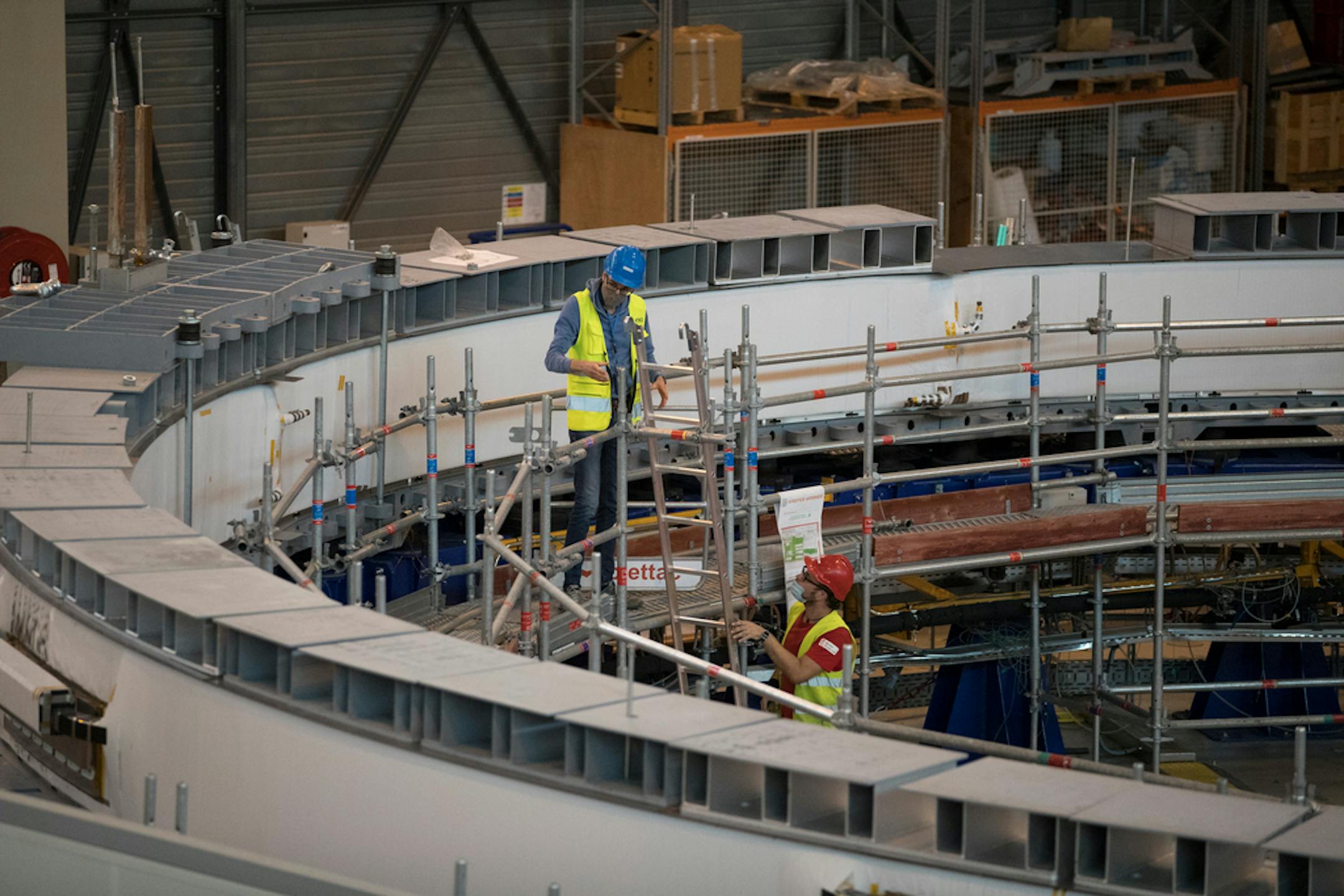 Technicians work on the poloidial field coil assembly line at the ITER (the International Thermonuclear Experimental Reactor) in Saint-Paul-Lez-Durance, southern France, Tuesday, July 28, 2020. A project of daunting proportions and giant ambitions replicating the energy of the sun is entering a critical phase as scientists and technicians begin piecing together massive parts built around the globe of a nuclear fusion device, an experiment aimed at showing that clean energy, free of carbon emissions, can keep our planet humming. (AP Photo/Daniel Cole)