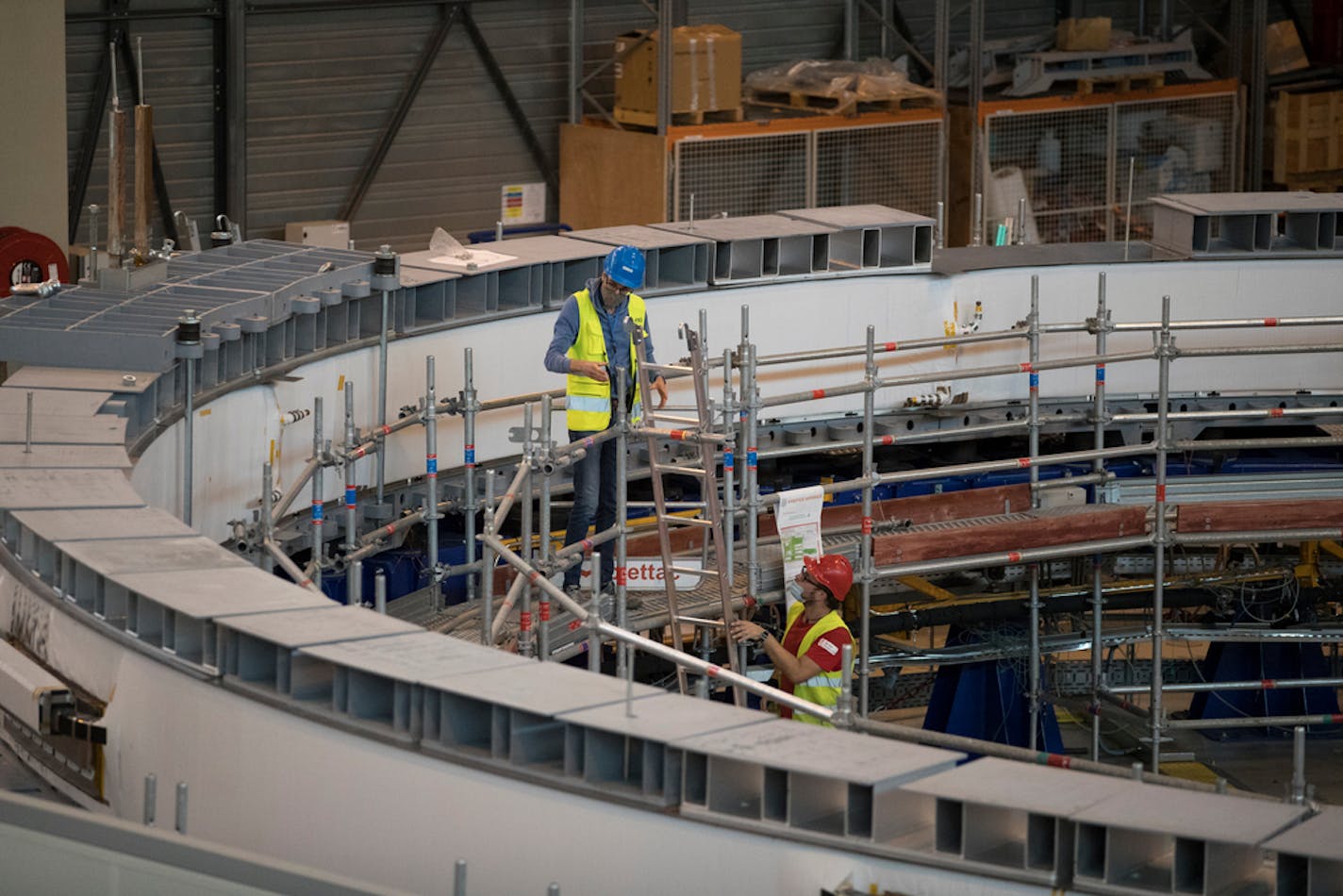 Technicians work on the poloidial field coil assembly line at the ITER (the International Thermonuclear Experimental Reactor) in Saint-Paul-Lez-Durance, southern France, Tuesday, July 28, 2020. A project of daunting proportions and giant ambitions replicating the energy of the sun is entering a critical phase as scientists and technicians begin piecing together massive parts built around the globe of a nuclear fusion device, an experiment aimed at showing that clean energy, free of carbon emissions, can keep our planet humming. (AP Photo/Daniel Cole)