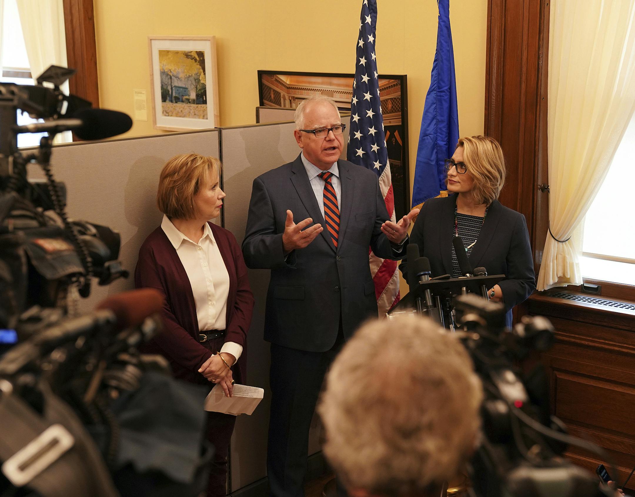 Gov.-elect Tim Walz, center, speaks during a news conference in the state Capitol Thursday, Nov. 8, 2018, in St. Paul, Minn., as Lt. Gov.-elect Peggy Flanagan, center right, and his wife Gwen Walz listen. (Anthony Souffle/Star Tribune via AP)