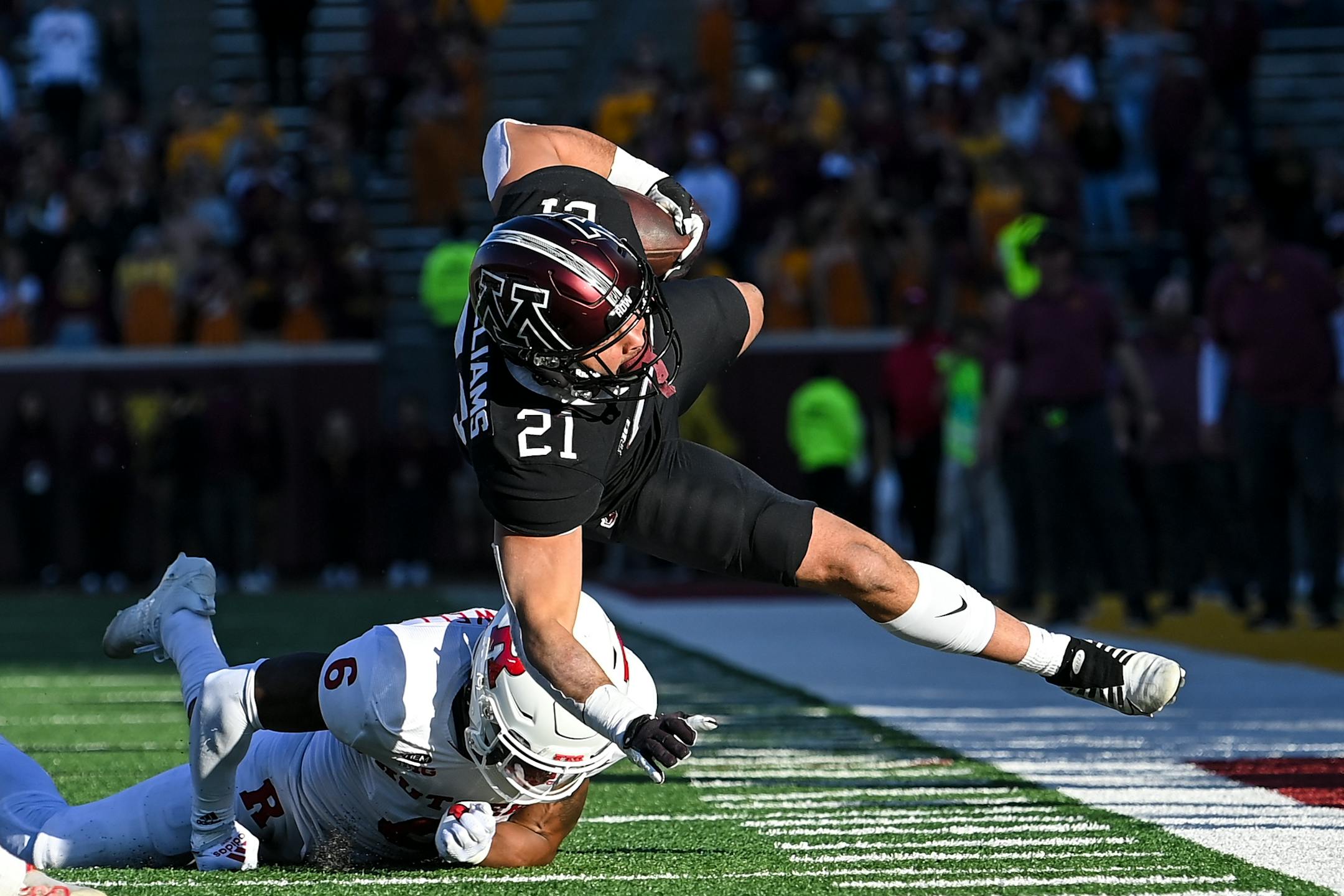 Minnesota Golden Gophers running back Bryce Williams (21) was knocked off his feet by Rutgers Scarlet Knights defensive back Christian Braswell (6) during the fourth quarter.
