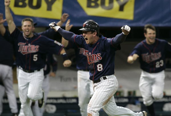 Minnesota Twins shortstop Nick Punto celebrates as he scores the winning run during the 10th inning of a baseball game against the Chicago White Sox o