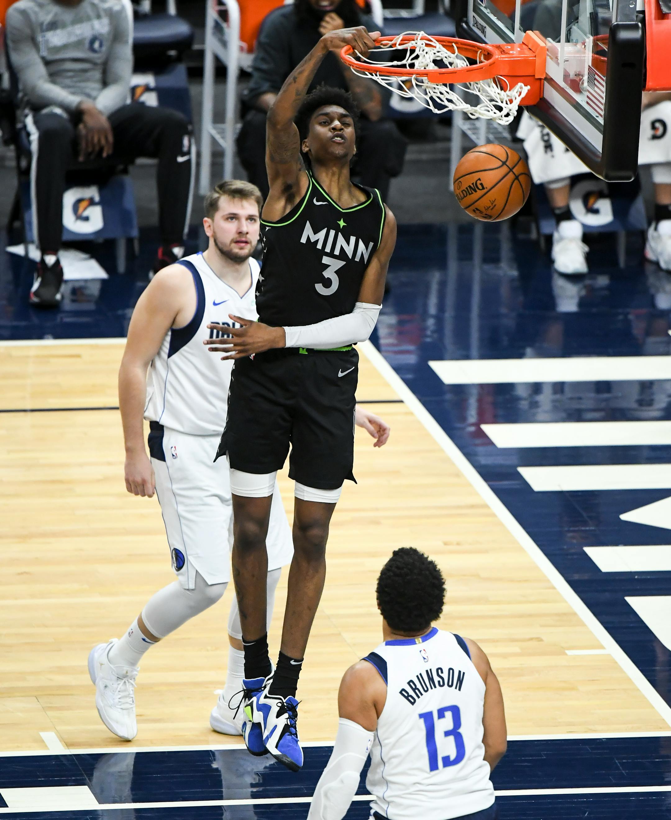 Minnesota Timberwolves forward Jaden McDaniels (3) dunked the ball beside Dallas Mavericks guard Luka Doncic (77) and guard Jalen Brunson (13) in the first half.