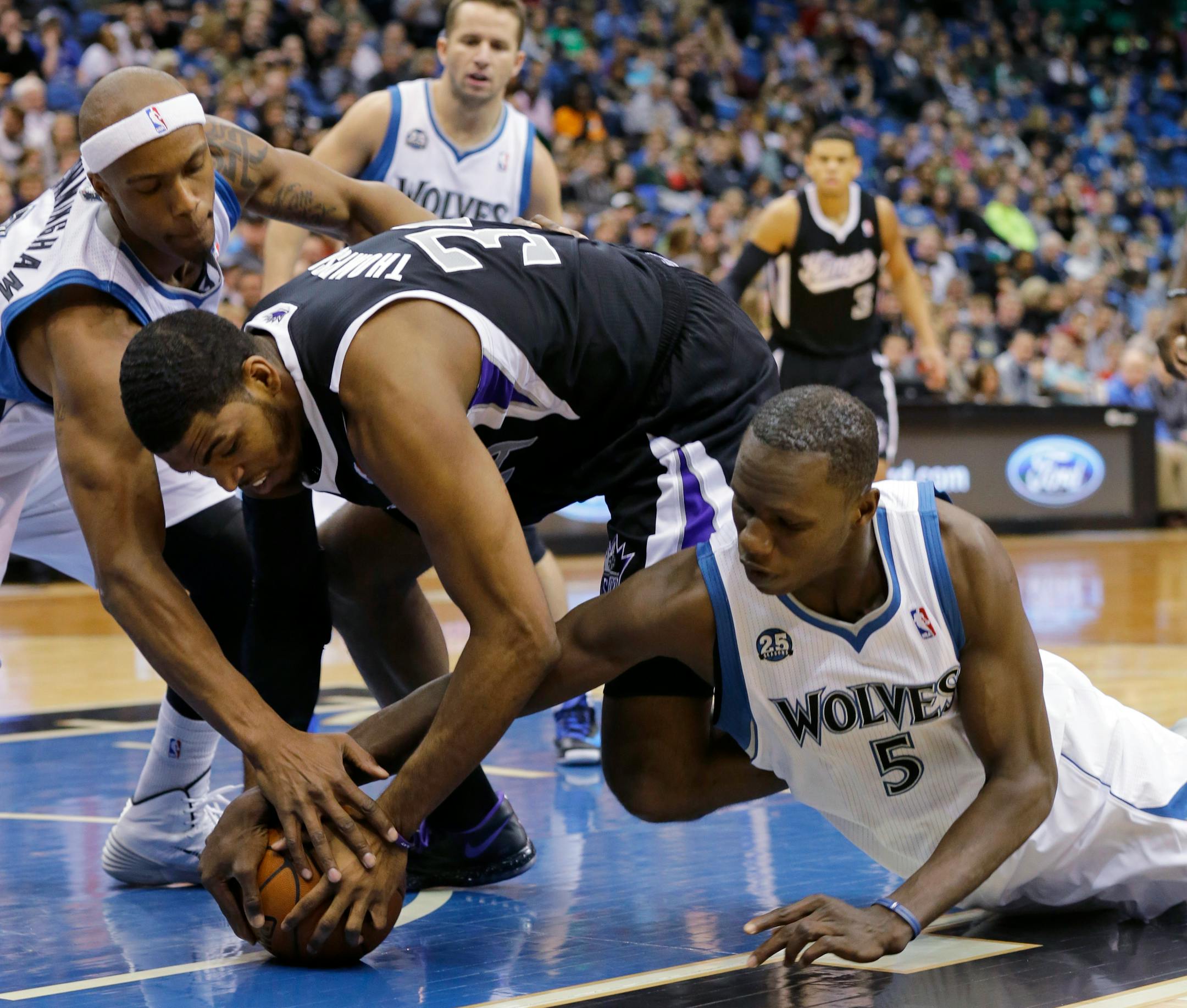 Minnesota Timberwolves forward Dante Cunningham, left, Sacramento Kings forward Jason Thompson, center, and Timberwolves center Gorgui Dieng (5) battle for a loose ball during the second quarter of an NBA basketball game in Minneapolis, Sunday, March 16, 2014. (AP Photo/Ann Heisenfelt)