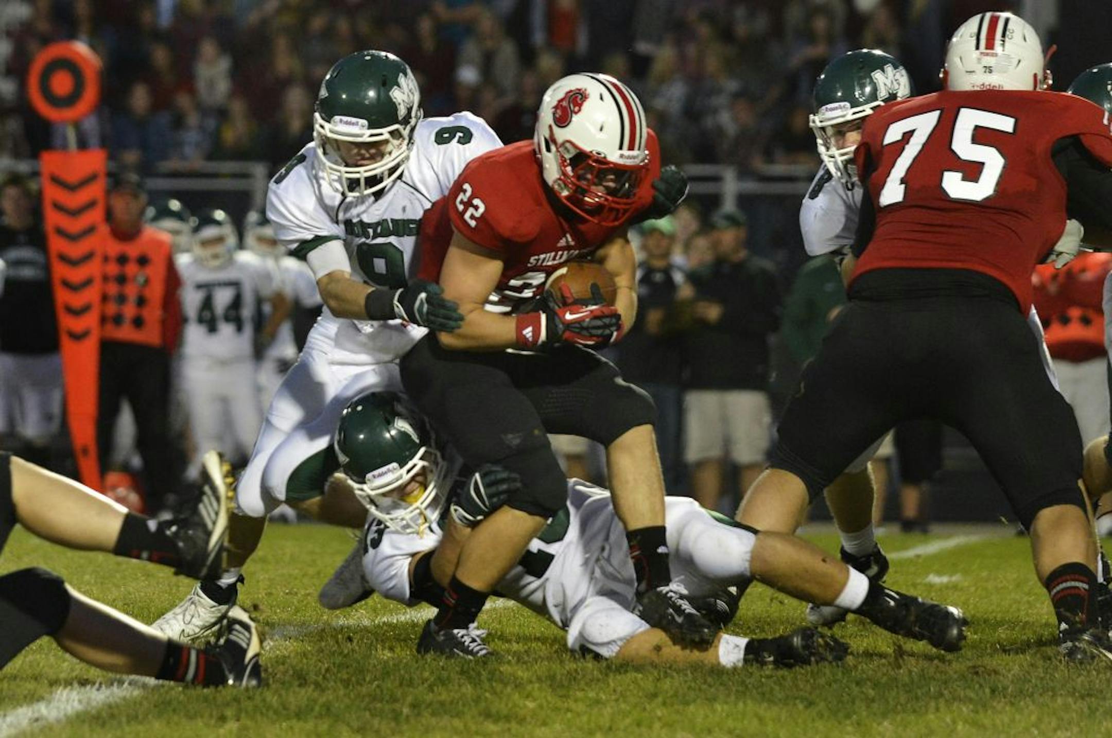 Stillwater's Nick Anderson (22) carries the ball up the field as Mound View's Ethan DeCaster (9) goes for the tackle during the first half of Mounds View at Stillwater, Friday, September 28.