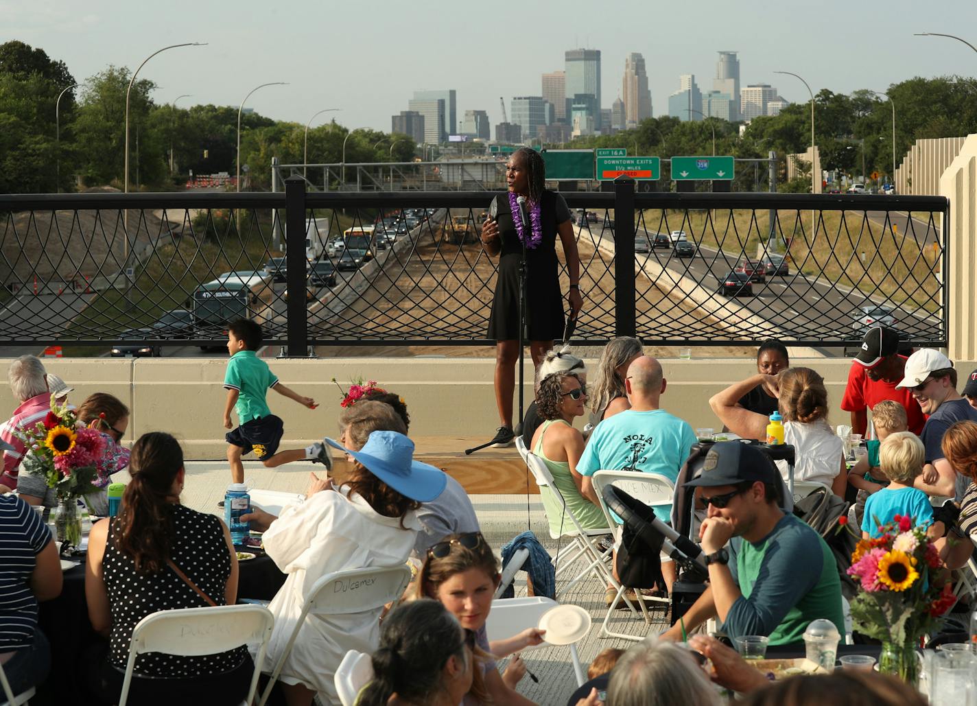 Minneapolis City Council Vice President Andrea Jenkins spoke as neighbors gathered for a family style dinner during the Building Bridges and Breaking Bread event on the I-35W bridge. ] ANTHONY SOUFFLE &#xef; anthony.souffle@startribune.com Neighbors gathered for the Building Bridges and Breaking Bread event that included kids' activities, live music and a sit-down, family-style meal on the 38th Street Bridge Thursday, Aug. 16, 2018 in Minneapolis. The event encouraged community dialogue and conv