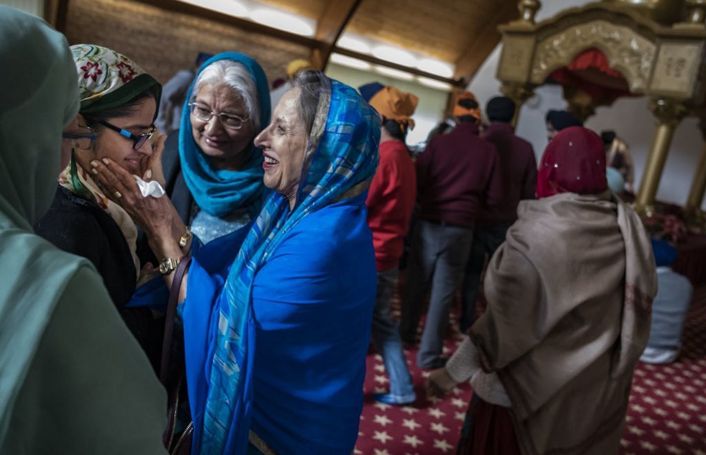 Gurpreet Kaur, who gave a sermon on the equality of men and women, a fundamental tenet of the Sikh faith is greeted by Bash Singh who praised her and cupped her face in her hands.