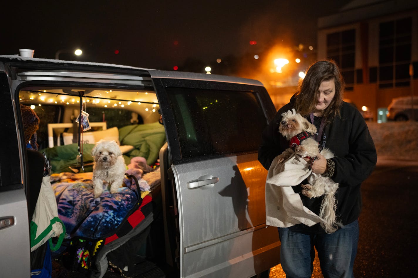 Lynette Ruse dried the feet of her dog, Bentley, after she let him and her other dog, Freya, get some fresh air before turning in for the night Monday, October 30, 2023 in Duluth. At night, the parking lot of the Damiano Center becomes Safe Bay, a place where unhoused people can sleep in their vehicles without fear for their safety. A mobile hygiene trailer has showers and bathrooms for people to use before they settle in for the night. Safe Bay is an initiative of Stepping On Up, a coalition of Duluth social service organizations, many of which are housed in the Damiano Center. ] JEFF WHEELER • Jeff.Wheeler@startribune.com