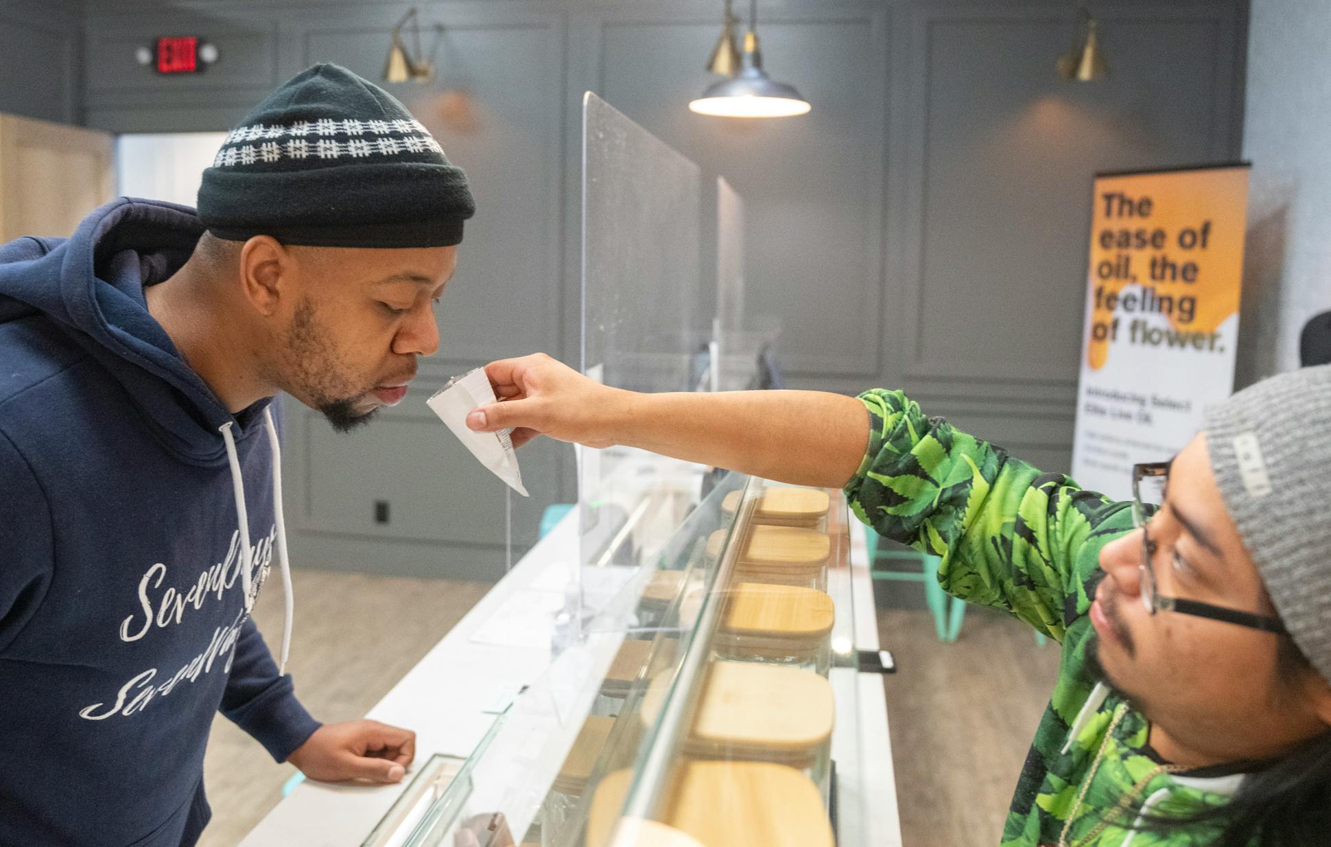 Shawn Triplett from Ann Arbor smells different strains of cannabis flower with help from Paul Manzo, a budtender at Herbana in Ann Arbor.