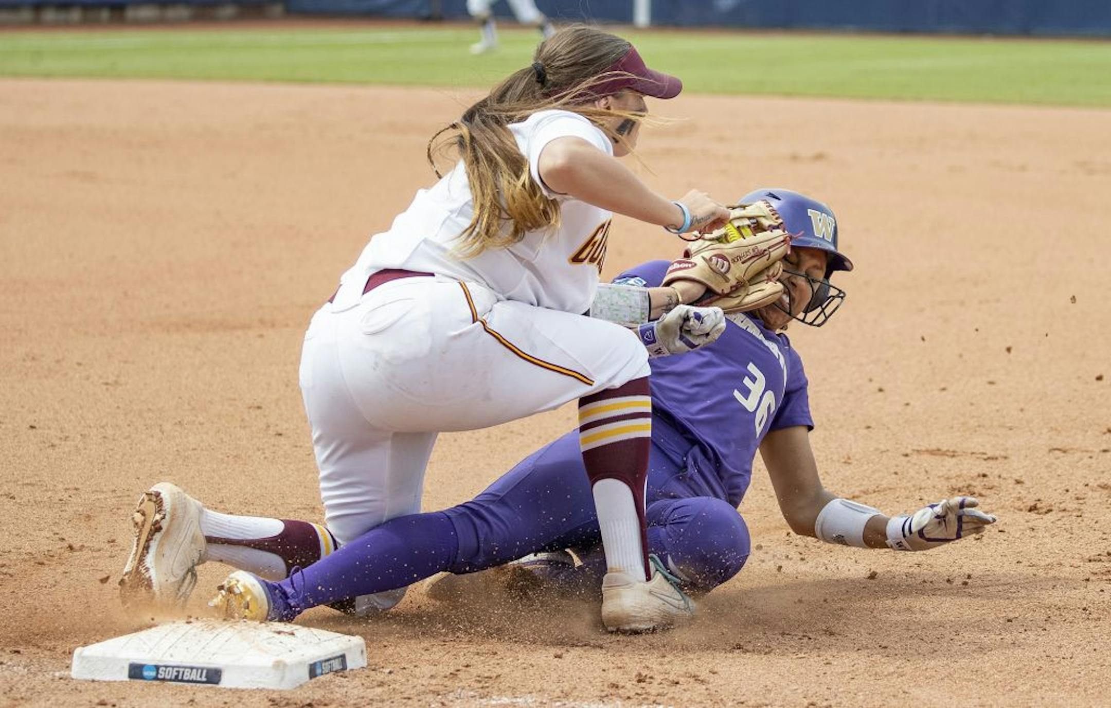 Minnesota's Hope Brandner tags out Washington's Amirah Milloy during the seventh inning of the Women's College World Series at ASA Hall of Fame Stadium in Oklahoma City on Saturday, June 1, 2019. Washington won 5-3. Photo by: Alonzo J. Adams