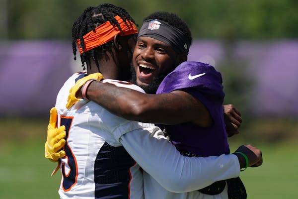 Minnesota Vikings wide receiver Ihmir Smith-Marsette (15) smiled as he hugged Denver Broncos cornerback Michael Ojemudia (13) during training camp Wed