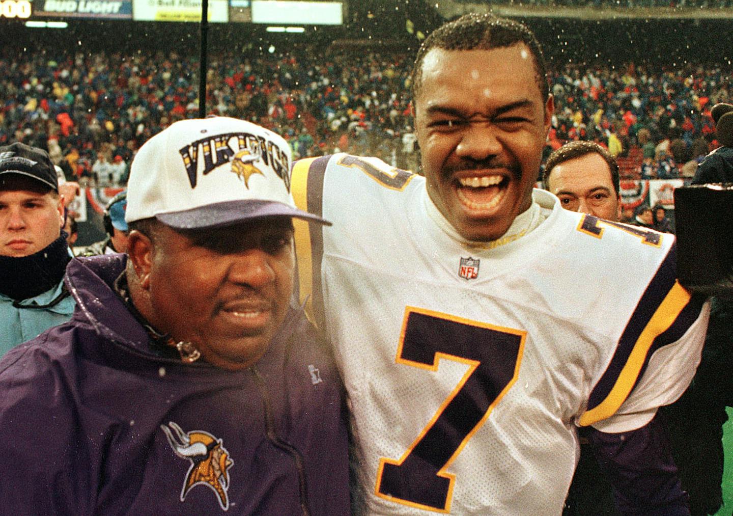 Dennis Green walks off the field with a jubilent Randall Cunningham after his 1st playoff win as coach of the Vikings.