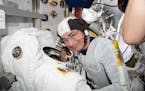 In this Aug. 17, 2021, photo made available by NASA, astronaut and Expedition 65 Flight Engineer Mark Vande Hei inspected a spacesuit in preparation f