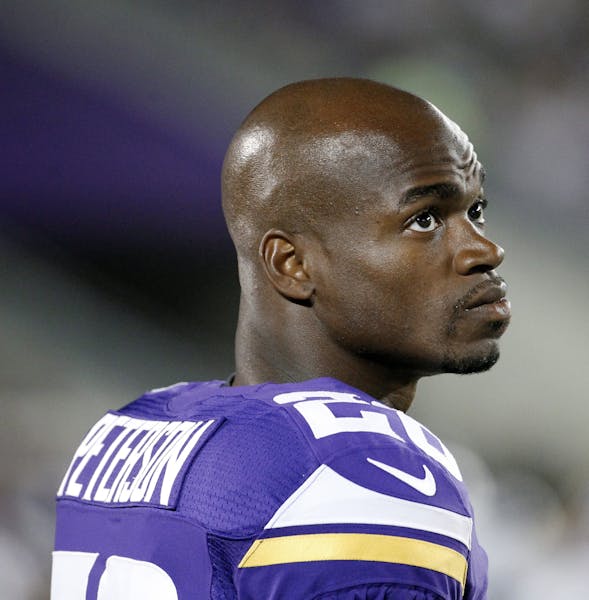 Minnesota Vikings running back Adrian Peterson watches from the sidelines against the Oakland Raiders during the second half of a preseason NFL footba