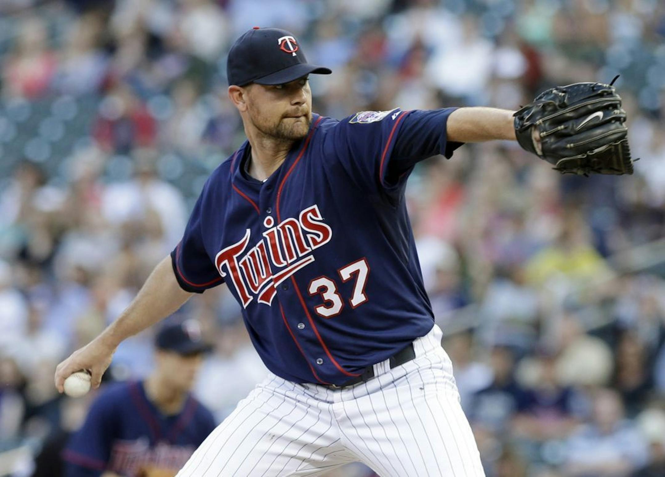 Mike Pelfrey winds up on a pitch against the Seattle Mariners in the first inning